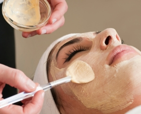 applying facial mask over a face by specialist in the salon